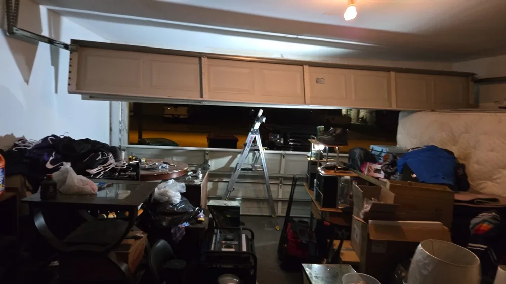 Interior garage repair scene with the door overhead and work equipment