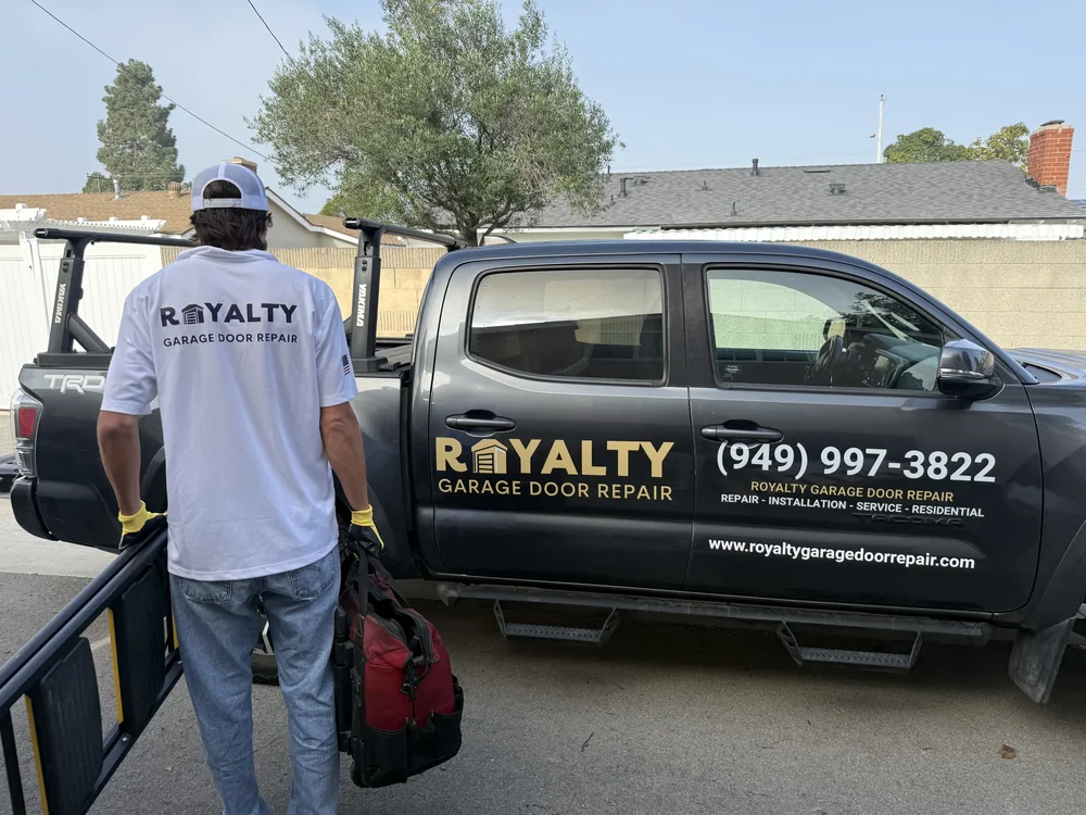 Uniformed Royalty technician beside the branded service truck