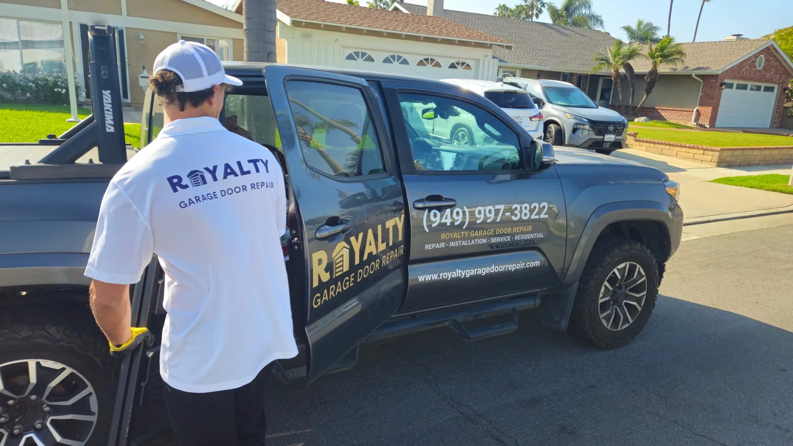 Uniformed Royalty technician at the branded Royalty service truck on a residential street